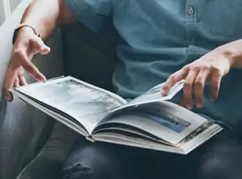 Hands holding a hardbound book open